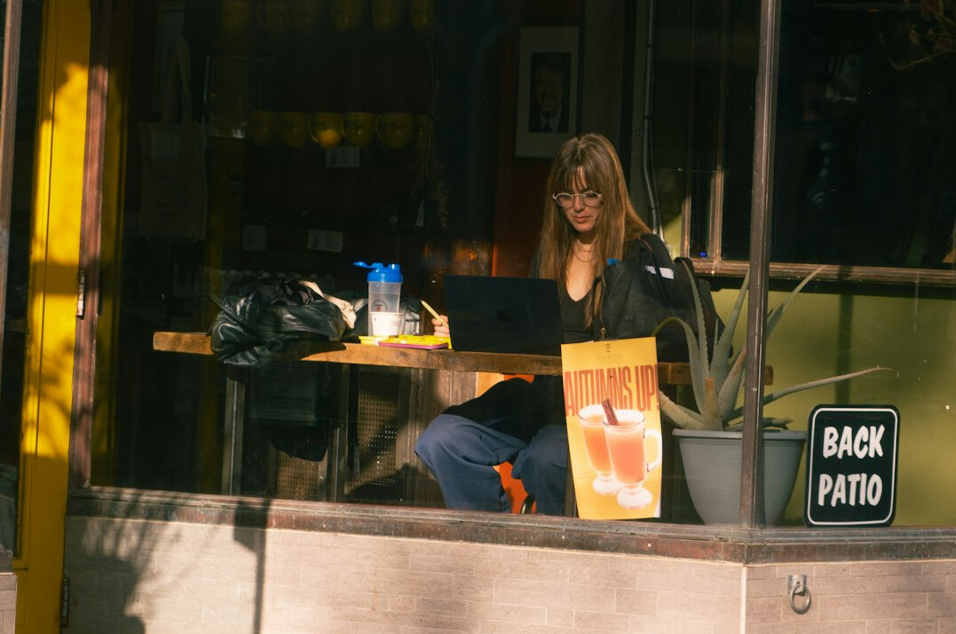 writer at laptop in cafe