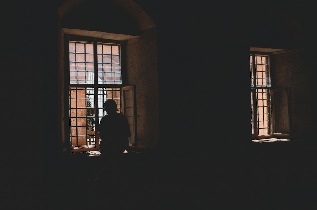 person looking out window at night
